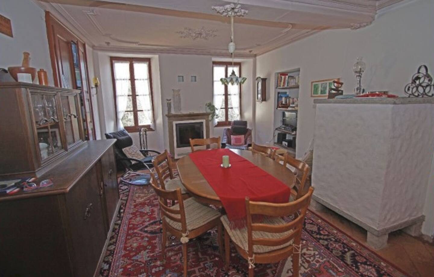 Esszimmer mit grossem Tisch und Cheminée