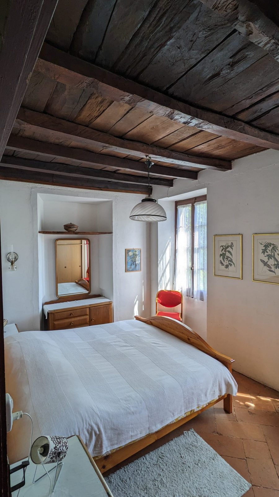 Schlafzimmer mit rustikaler Holzbalkendecke
